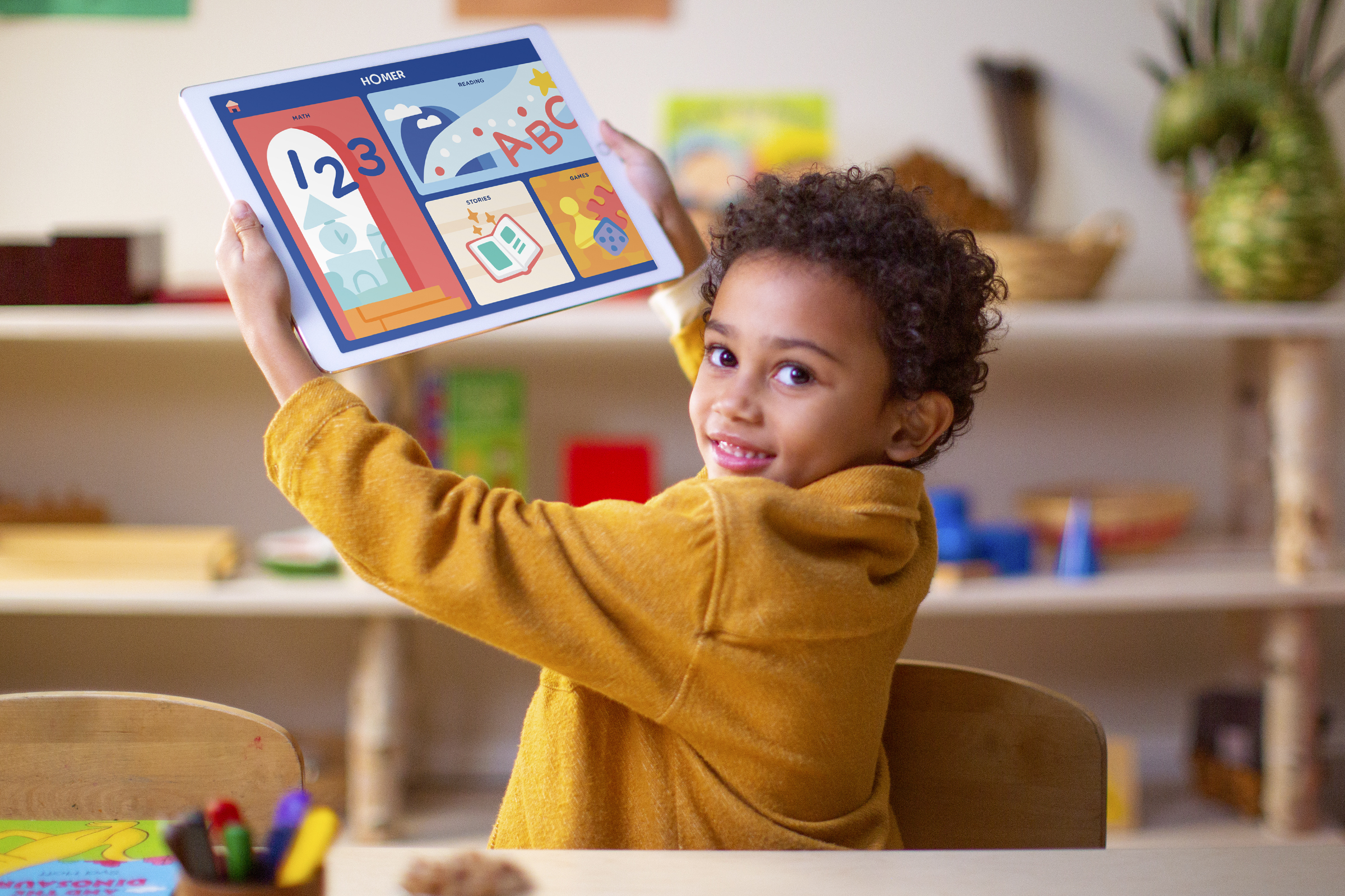 Child holding a tablet showing the HOMER Learn and Grow home screen in a bright playroom